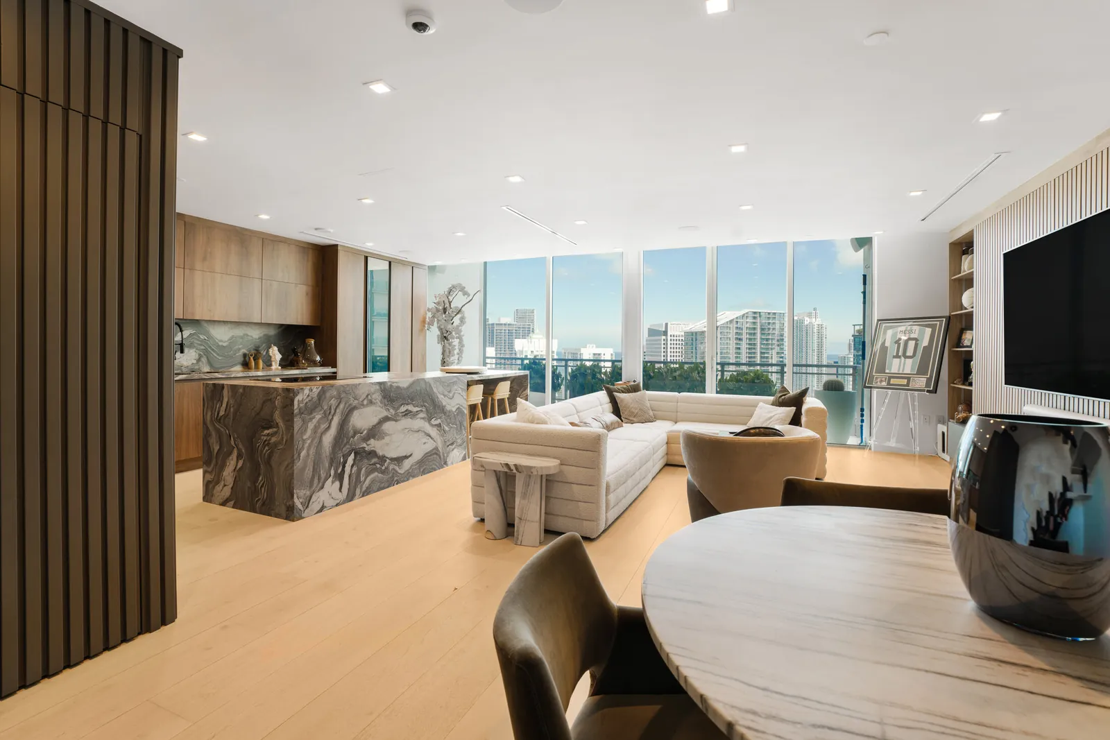 Sala abierta y cocina con isla de mármol, con ventanales de piso a techo sobre Brickell